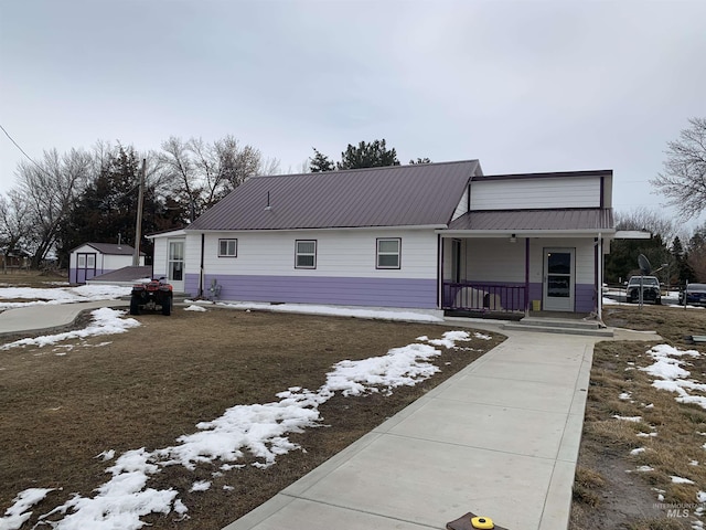 view of front of home with a porch and a storage unit