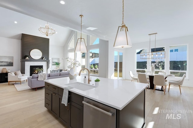 kitchen featuring a sink, light wood-style floors, dishwasher, and light countertops