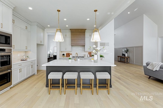 kitchen featuring appliances with stainless steel finishes, light countertops, and a kitchen breakfast bar