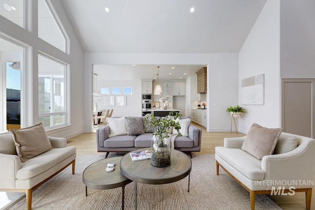 living room featuring recessed lighting, light wood-type flooring, and high vaulted ceiling