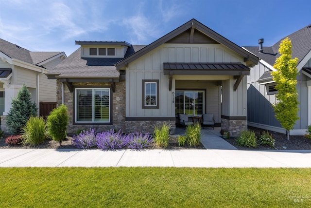 6178 N Bolsena Ln, Meridian, ID 83646 - view of front facade with board and batten siding, stone siding, roof with shingles, and a front lawn