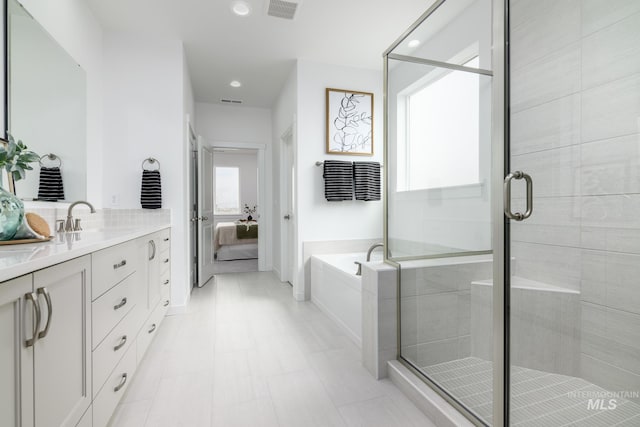 2005 N Spring Creek Ave, Middleton, ID 83644 - ensuite bathroom with double vanity, a garden tub, a stall shower, recessed lighting, and baseboards