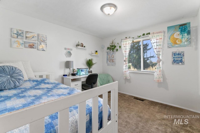 bedroom with built in desk and carpet flooring