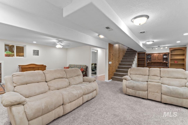 carpeted living room with a textured ceiling and ceiling fan