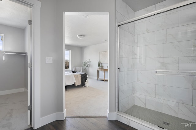 1694 N Solterra Ln, Meridian, ID 83646 - bathroom with baseboards, connected bathroom, a stall shower, and wood finished floors