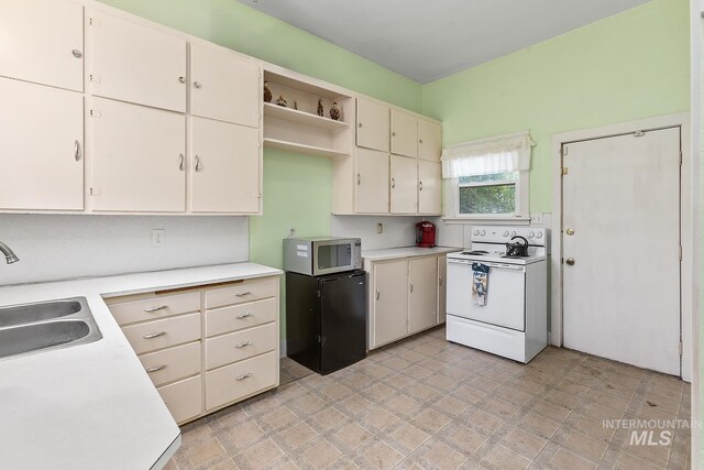 408 6th Ave, Lewiston, ID 83501 - kitchen featuring electric range, stainless steel microwave, light countertops, and open shelves
