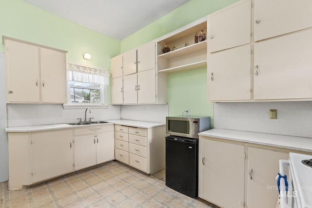 408 6th Ave, Lewiston, ID 83501 - kitchen featuring stainless steel microwave, light countertops, open shelves, black refrigerator, and white stove