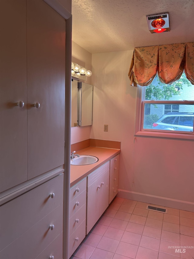 bathroom with a textured ceiling, visible vents, tile patterned flooring, baseboards, and vanity