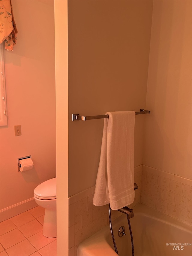 full bathroom featuring tile patterned flooring, toilet, and a bath