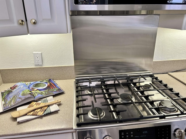 details featuring a textured wall and gas stove