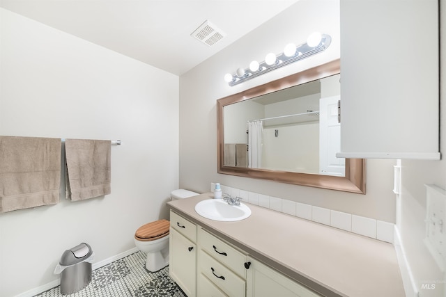 bathroom with vanity, tile floors, and toilet