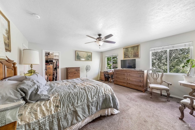 bedroom featuring a closet, carpet floors, a spacious closet, ceiling fan, and a textured ceiling