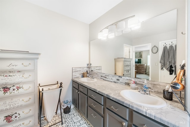 bathroom featuring tile flooring, double sink vanity, and tasteful backsplash