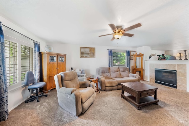 living room with ceiling fan, carpet floors, and a tiled fireplace