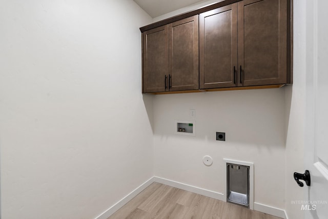 clothes washing area with light wood finished floors, baseboards, hookup for a washing machine, cabinet space, and electric dryer hookup