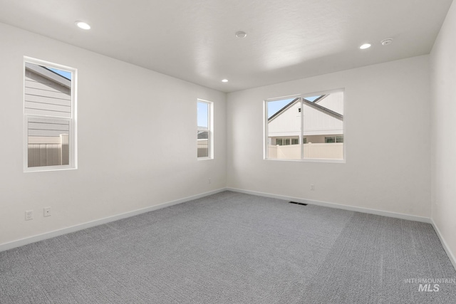 empty room featuring visible vents, recessed lighting, baseboards, and carpet floors