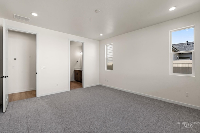 unfurnished bedroom featuring recessed lighting, visible vents, carpet floors, and baseboards