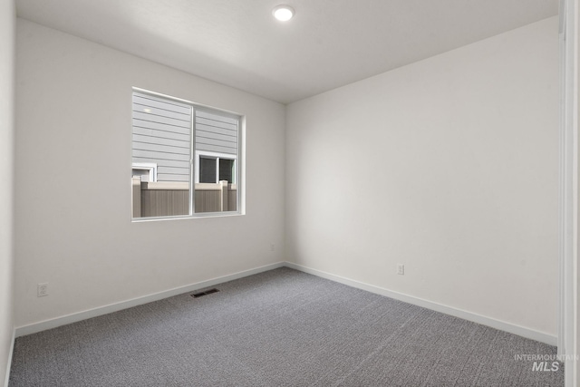 carpeted empty room with visible vents and baseboards