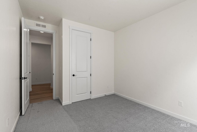 unfurnished bedroom with visible vents, baseboards, and carpet