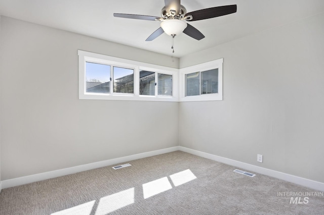 spare room with baseboards, a ceiling fan, visible vents, and carpet floors
