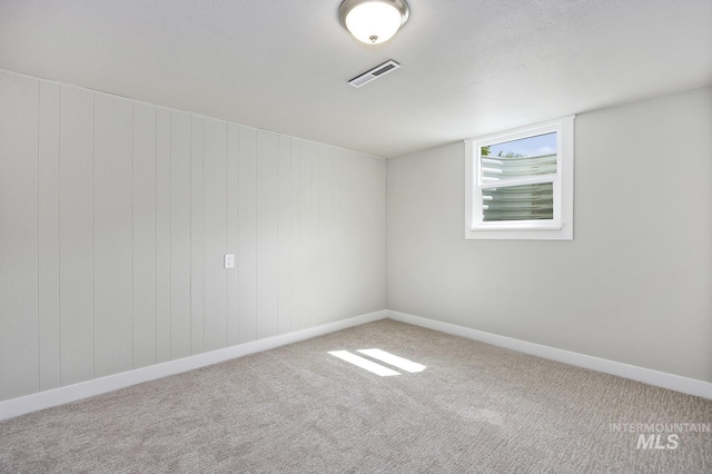 empty room with carpet, baseboards, and visible vents
