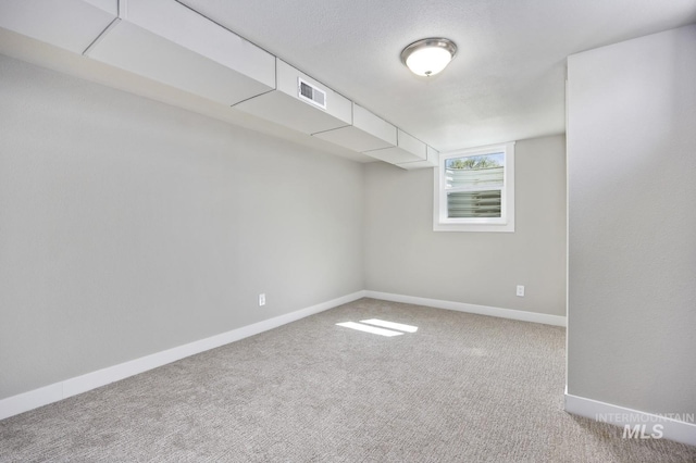 basement with visible vents, baseboards, and carpet floors