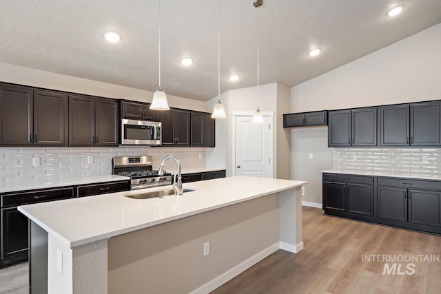 19257 Red Eagle Way, Caldwell, ID 83605 - kitchen with stainless steel appliances, a sink, light wood finished floors, tasteful backsplash, and vaulted ceiling