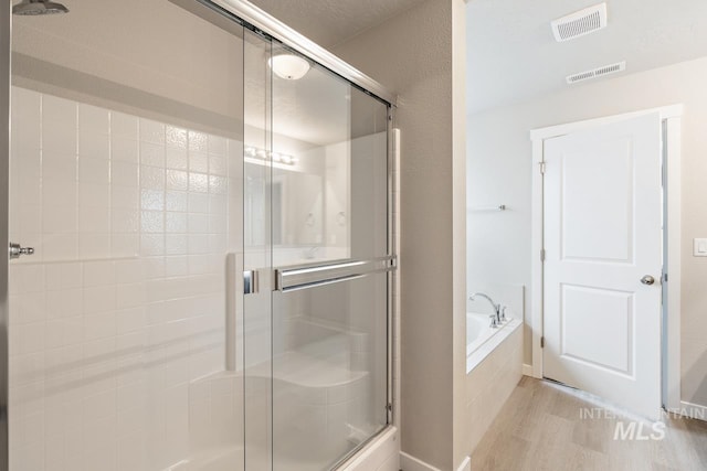 19257 Red Eagle Way, Caldwell, ID 83605 - bathroom with wood finished floors, a shower stall, and a garden tub