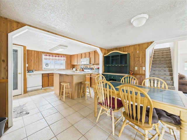 1334 Morehouse Rd, Emmett, ID 83617 - dining room with wooden walls, light tile patterned floors, stairway, and a textured ceiling