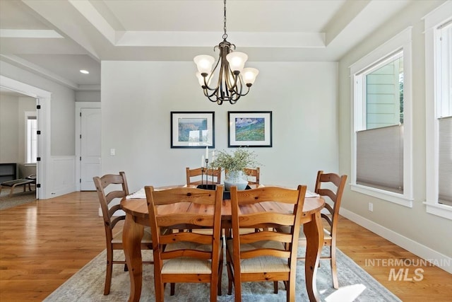 dining area with a chandelier, light wood-style flooring, a tray ceiling, and recessed lighting