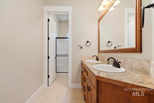 bathroom with tile patterned flooring, double vanity, and baseboards
