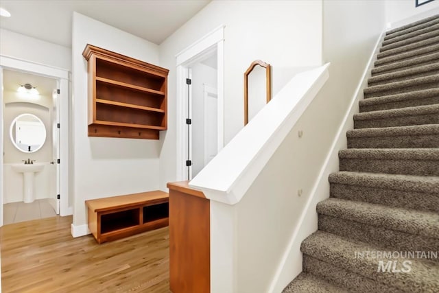 stairs featuring wood finished floors and baseboards