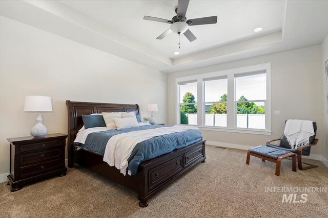 bedroom with light carpet, baseboards, a tray ceiling, and recessed lighting