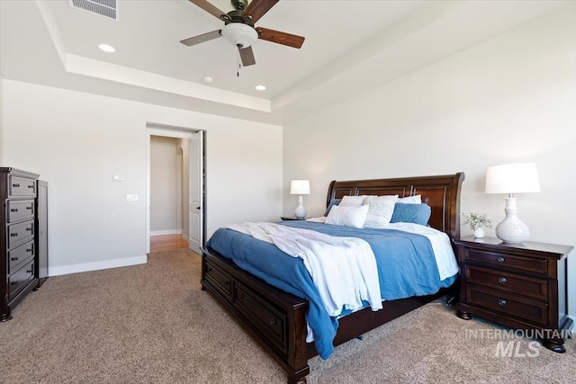 bedroom featuring light carpet, a raised ceiling, baseboards, recessed lighting, and a ceiling fan