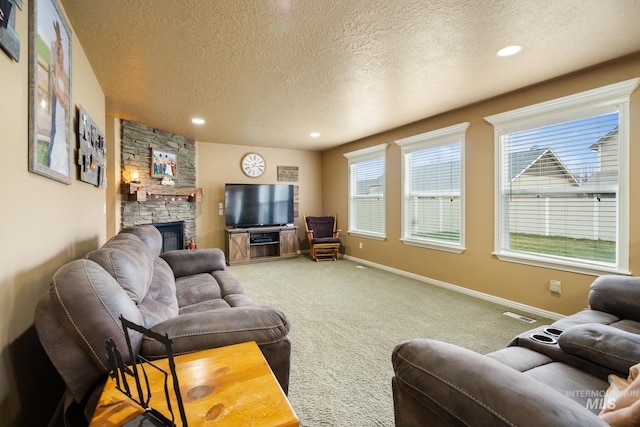 carpeted living room with a stone fireplace and a textured ceiling