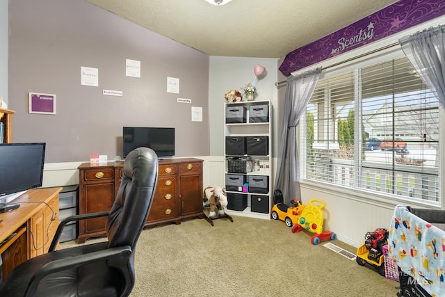 carpeted office space featuring a textured ceiling