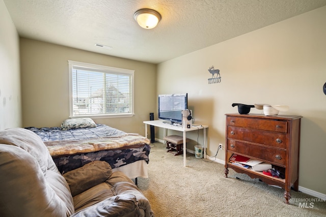 bedroom with carpet and a textured ceiling