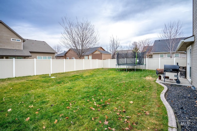 view of yard featuring a trampoline and a patio