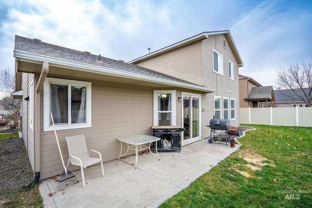 back of property with a lawn and a patio