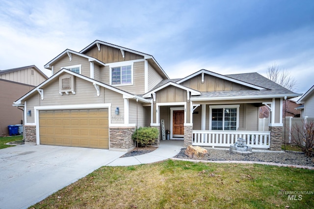 craftsman inspired home featuring a porch, a garage, and a front lawn