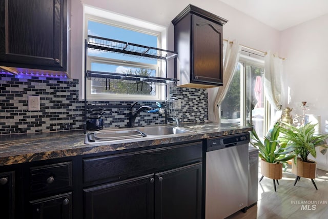 kitchen featuring tasteful backsplash, light wood-type flooring, dark brown cabinets, stainless steel dishwasher, and sink