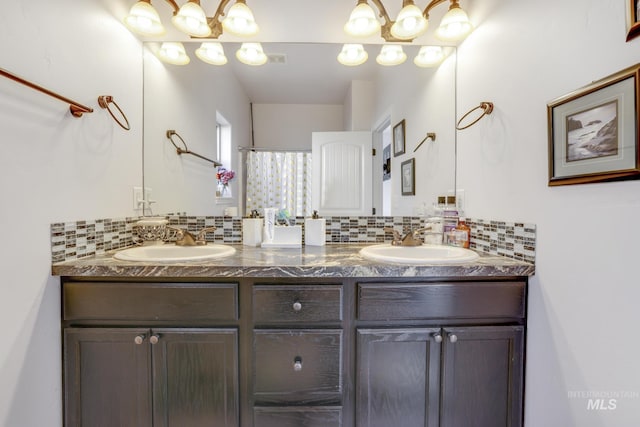 bathroom with double vanity, decorative backsplash, visible vents, and a sink