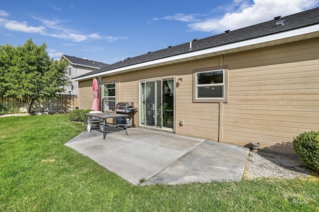 rear view of property with a yard, a patio, and fence