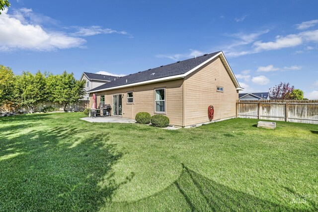 rear view of house with a yard and a patio