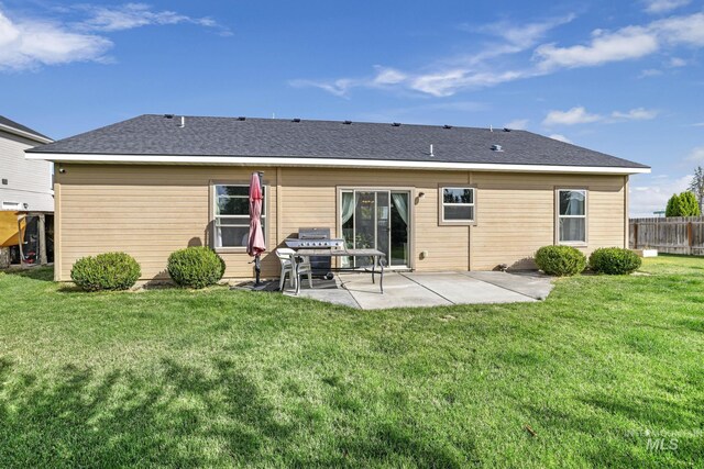 rear view of property featuring a yard and a patio