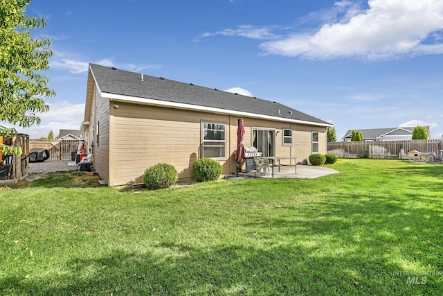 rear view of house with a yard, a fenced backyard, and a patio area