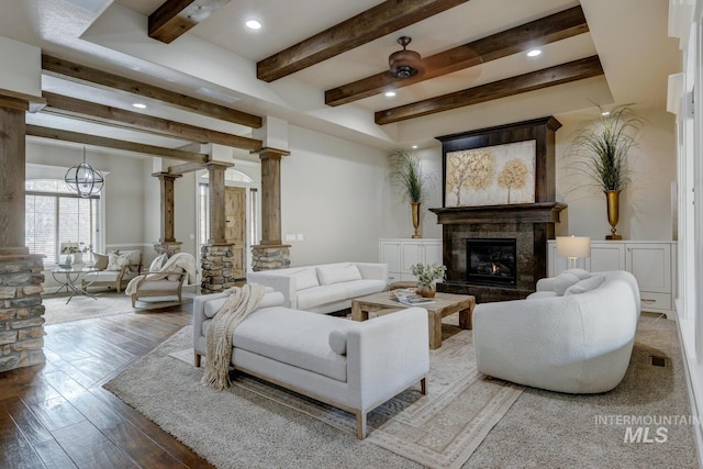 living room featuring wood-type flooring, a high end fireplace, and ornate columns