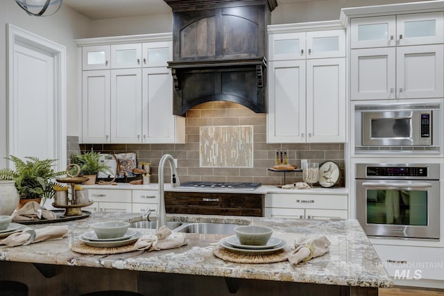 kitchen with white cabinetry, appliances with stainless steel finishes, tasteful backsplash, and a kitchen breakfast bar