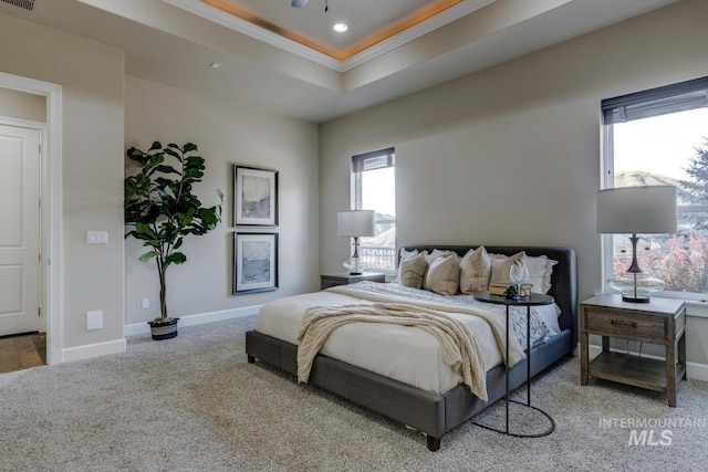 bedroom with ceiling fan, crown molding, a raised ceiling, and carpet flooring