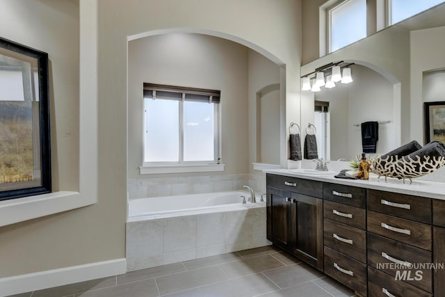 bathroom with vanity, tiled tub, and tile patterned floors